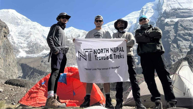 Exploration group from North Nepal Trek holding banners of North Nepal trek after sucessful exploration of North Annapurna Base Camp, with the snow white Annapurna on the background.